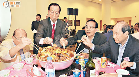 劉皇發（左二）以主人家身份幫手「撈起」盆菜。右一、二分別是鄉議局副主席張學明及劉秀成。