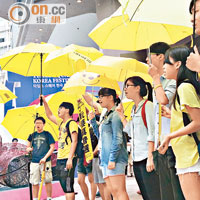 銅鑼灣<br>一批中學生在時代廣場高舉黃傘及唱歌撐佔中。