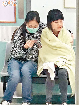 被惡蟲咬傷手指女警（右）在醫院候診。（曾志恒攝）