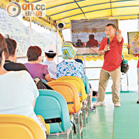 兩名持牌導賞員向參加導賞船團的團友講解地質公園資料。