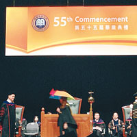 有學生手持黃雨傘上台接受畢業證書，遭浸大校長陳新滋（右）拒絕頒授。（互聯網圖片）