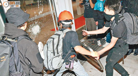 示威者用鐵欄狂撼立法會大樓的玻璃門。