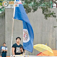 豎港英旗<br>經常作「美國隊長」打扮的男子穿便裝到領事館，站在港英龍獅旗旁。