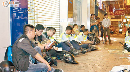 與佔領者對峙過後，部分警員坐在路邊休息。