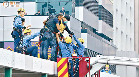 男事主由消防員協助離開天橋頂。（馬竟峯攝）