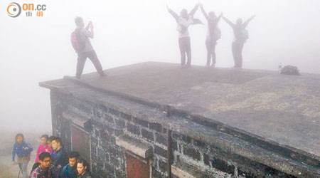 大東山數名遊人爬上「爛頭營」的屋頂拍照，驚險萬分。