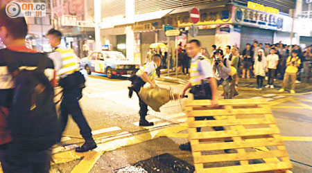 警員在永星里及彌敦道交界，清走示威者以垃圾桶及卡板製成的路障。