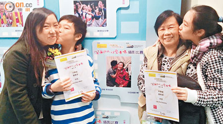 林太（左一）的子女拍下家庭溫馨一面獲頒優異獎，其子（左二）及女兒（右一）分別向媽媽及外婆送上一吻。（梁可瑩攝）