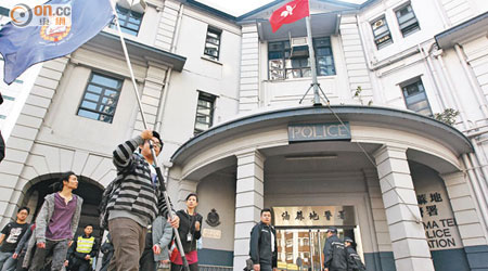 示威者在油麻地警署外揮舞皇家香港警察旗幟。