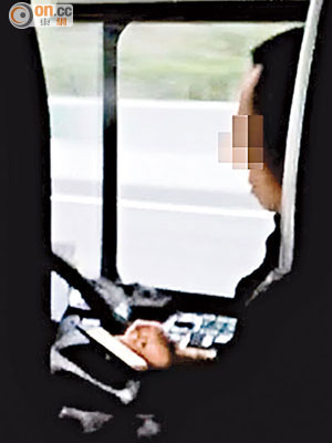 跨境巴士司機在高速公路駕車時邊玩手機、邊單手控制軚盤，險象環生。