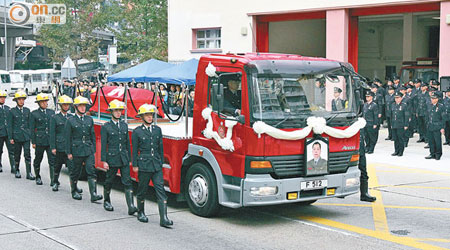 十多名同袍伴着靈車，徐徐經過基哥生前駐守的旺角消防局。（鄧業榆攝）