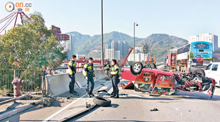 肇事的士翻轉，車頭嚴重損毀。（曾紹良攝）