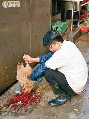 深圳<br>小販在深圳街市徒手劏雞。