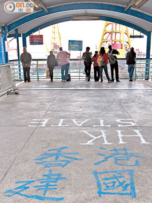 海港中心往舊灣仔碼頭的行人天橋地面被塗寫字句。