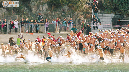 參賽者在鳴槍後隨即投身大海游冬泳。（蘇文傑攝）