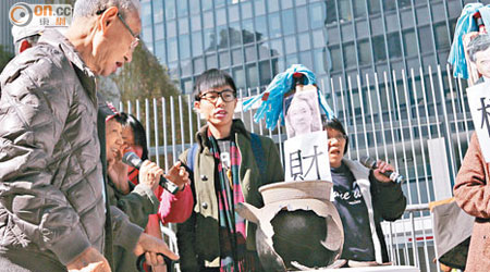 示威團體敲碎寫上「施政失誤十宗罪」的瓦煲，諷刺當局的民生政策是「無米粥」。