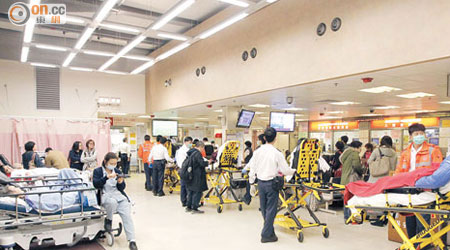 伊院急症室積滿經救護車送院的長者，病人排成一行等候分流診治。（高嘉業攝）