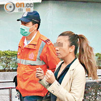 疑被丈夫毆打的菲裔女子（右）由救護員送院。