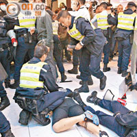 示威者和警方昨在商場內爆發衝突，有示威者被警員制服在地上。（羅錦鴻攝）