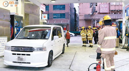 報稱入多油的私家車懷疑漏油，消防員到場戒備。（麥少峰攝）