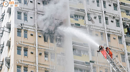 消防員用雲梯向起火單位射水。 （黃君堡攝）