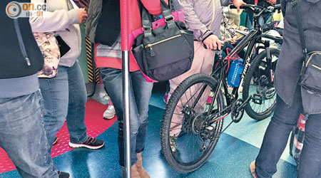 有乘客推着一部未拆轆單車進入車廂，對其他乘客構成不便。