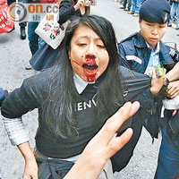 有參與遊行的女子口鼻流血被警員帶走。