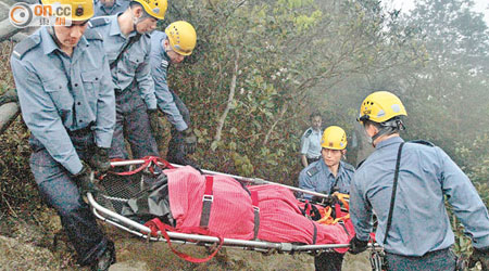 消防員合力將死者遺體抬落山。