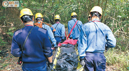 消防員將死者遺體抬落山。（陳錦昌攝）