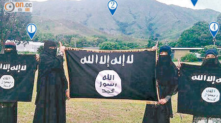 四名女信眾去年十月在元朗一俱樂部草地，手執與IS所使用的同款式旗幟合照。