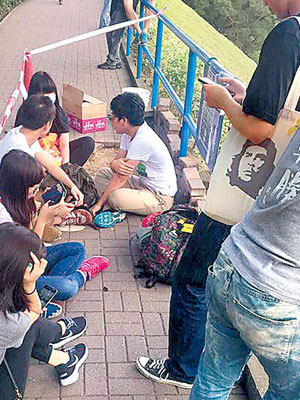 多名學生坐在地上阻止工人更換地磚。（互聯網圖片）