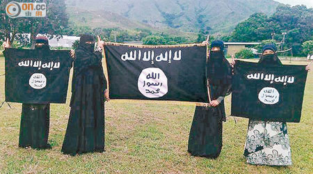四名女信眾去年十月在元朗的俱樂部，手執與IS所使用的同款式旗幟合照。（資料圖片）
