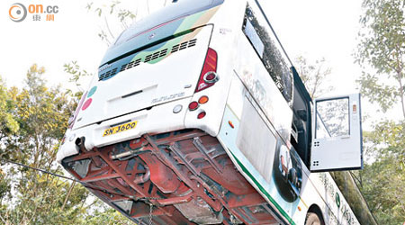 巴士車底被石壆卡住。（林兆崙攝）