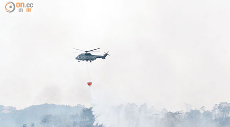 直升機在下白泥山火現場擲水彈。（文健雄攝）