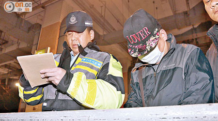 戴鴨舌帽及口罩的「黑的」司機被捕。（馮裕亨攝）