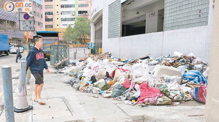 大量建築廢料遭棄置於行人路，行人亦為之側目。