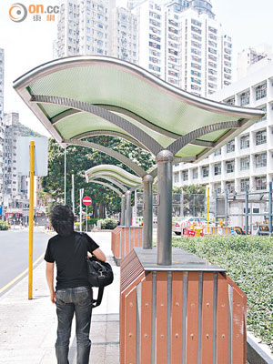 避雨亭基座佔去上蓋逾七成面積，記者僅能勉強「避雨」。