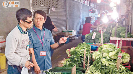 Gary（右）正以觸感手語與阿Lam（左）溝通，告知他街市菜價，協助他買餸。