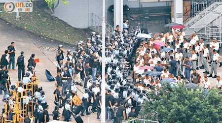 示威者與警員對峙，期間有示威者高舉雨傘衝擊。（梁鵬威攝）