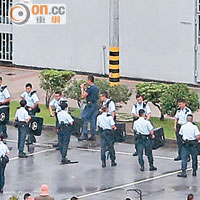 港島總區應變大隊人員昨冒雨在大操場上圍圈排隊學習適當使用警棍。