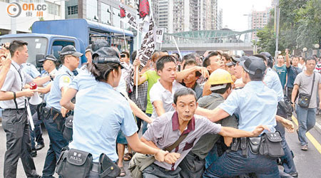 有工人在遊行期間企圖衝出馬路，警員上前勸止場面混亂。