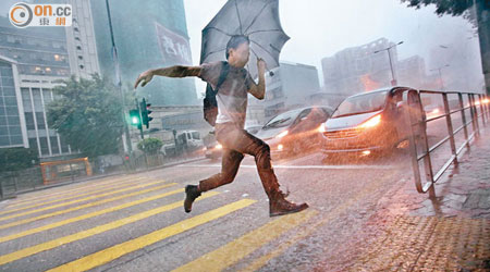 在滂沱大雨下，市民顯得十分狼狽。（黃永俊攝）