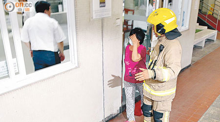 吸入甲醛的婦人由消防員安排離開大廈。（張曉楠攝）