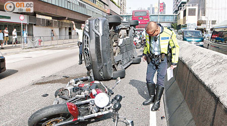 房車撞石壆翻側，再遭電單車從後撞及。（張世洋攝）