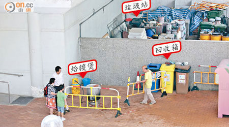 陳笑文露天石油氣煮糉地點旁近回收箱，牆後是垃圾站。