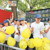 「保衛香港力量」成員篤爆黃色氣球，象徵篤破泛民謊言。（何頴賢攝）