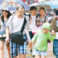 大驟雨突然來襲，沒有帶備雨具的市民狼狽走避。（高嘉業攝）