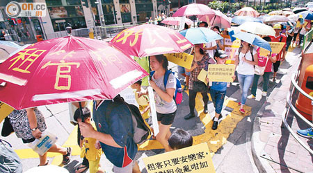 遊行隊伍撐起雨傘遊行，寓意「撐租管」。（黃仲民攝）