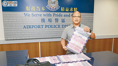 機場警區總督察（刑事）葉春榮展示前日在疑犯身上搜出的人民幣。