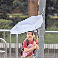 雨傘不敵暴雨，台北行人狼狽不堪。（中央社圖片）